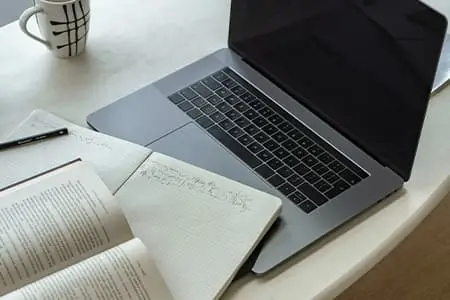 notebook junto com anotações, representa início da livraria online